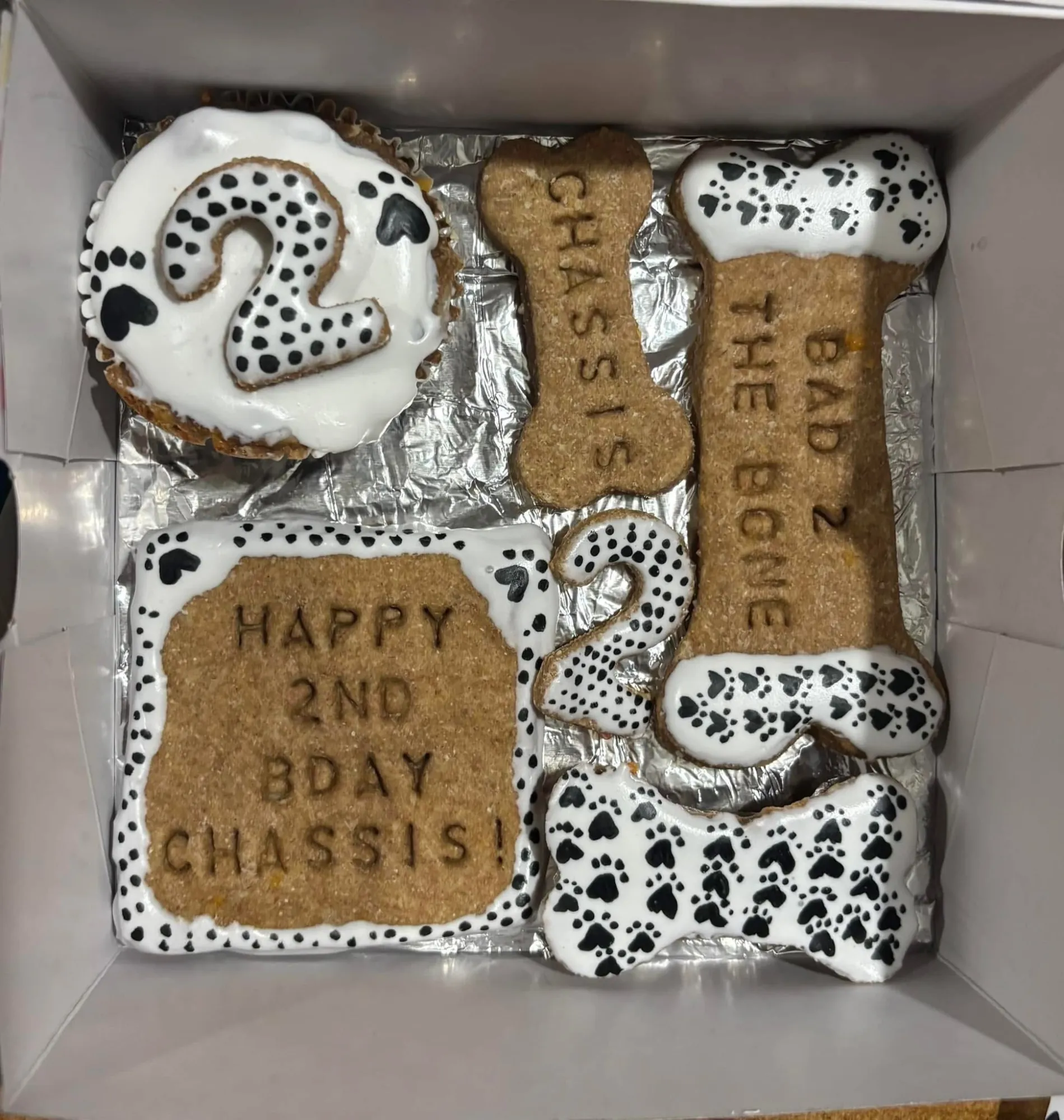 Dalmatian themed dog birthday treats with black spotted icing and a Bad to the Bone cookie