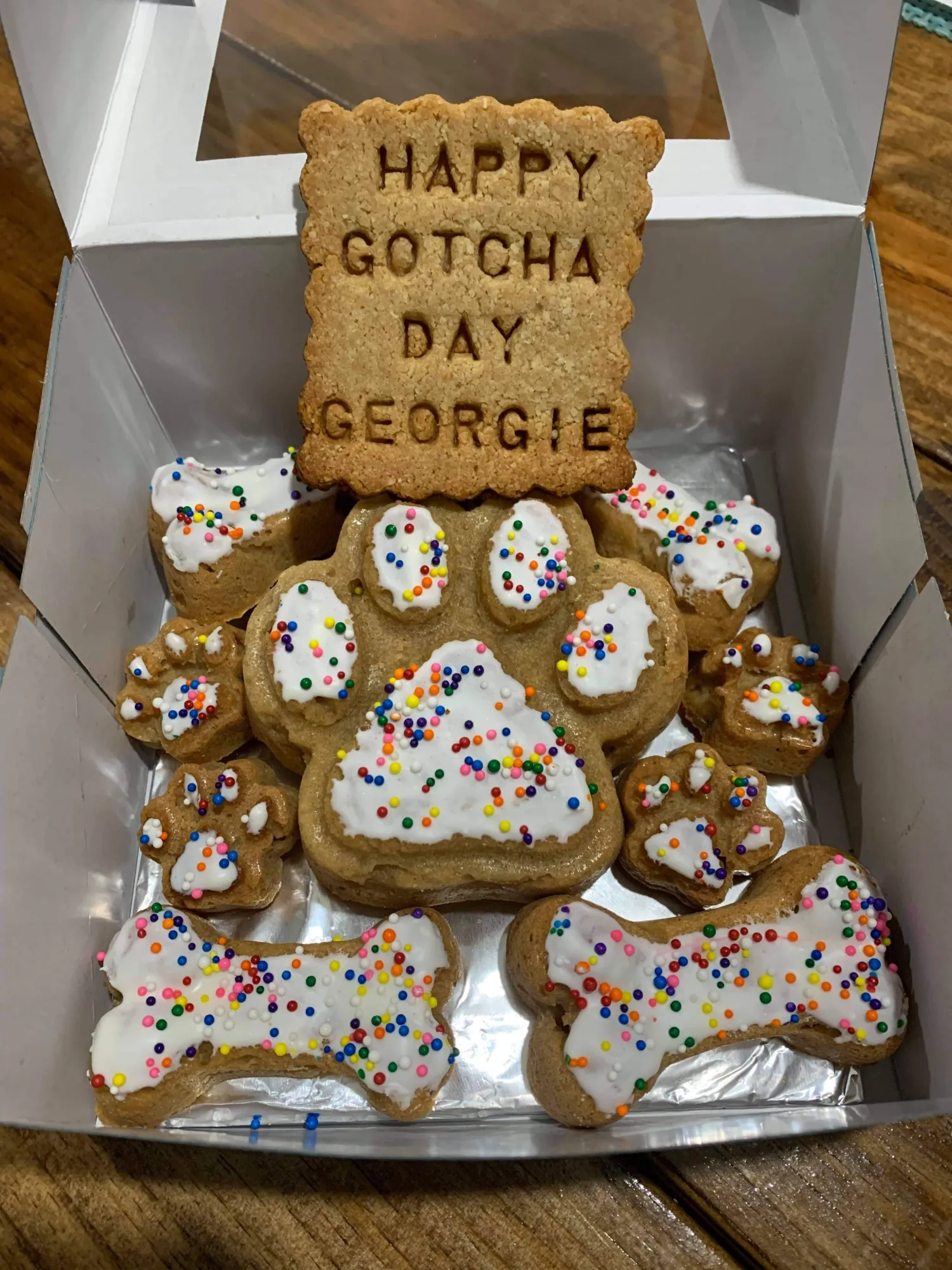 Gotcha day dog paw cake with white icing and rainbow sprinkles