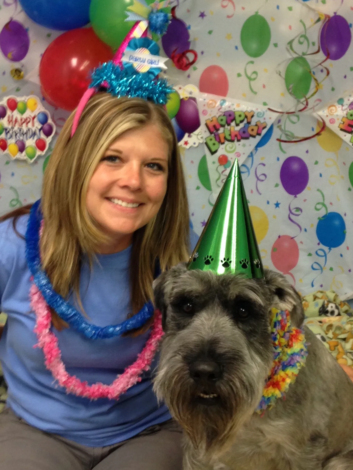 Shiloh Keuler in a party hat celebrating a dog birthday with a schnauzer